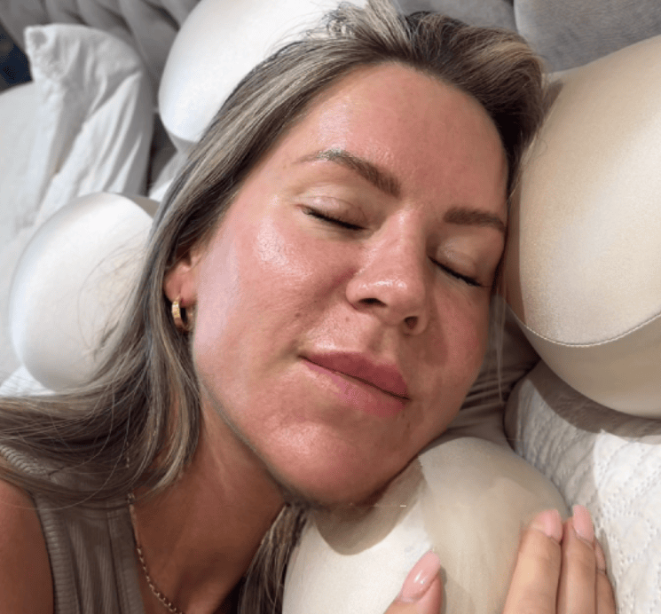 Woman sleeping on Serene SKN Co anti-wrinkle ergonomic sleep pillow in beige, close up showing no sleep lines or face compression