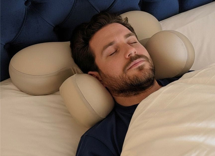 Man sleeping on Serene SKN Co anti-wrinkle ergonomic sleep pillow in beige, back sleeping position against a luxury navy velvet headboard