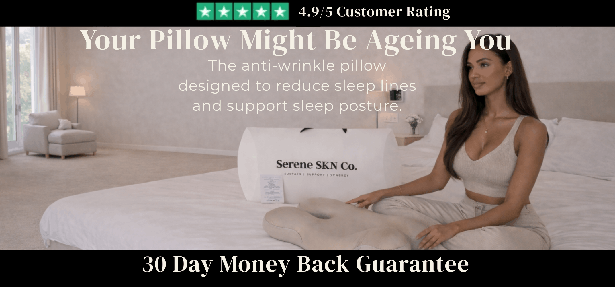 Serene SKN Co anti-wrinkle ergonomic sleep pillow in beige, lifestyle hero image with model seated on bed in a luxury bedroom setting