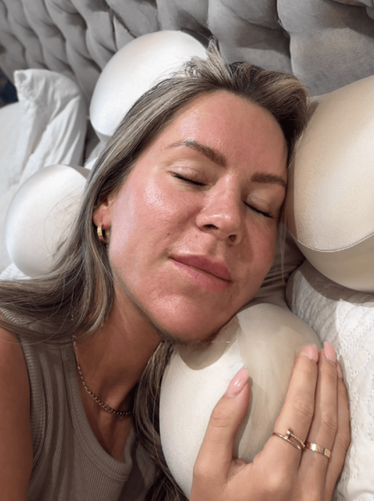 Woman sleeping on Serene SKN Co anti-wrinkle ergonomic sleep pillow in beige, close up showing no sleep lines or face compression